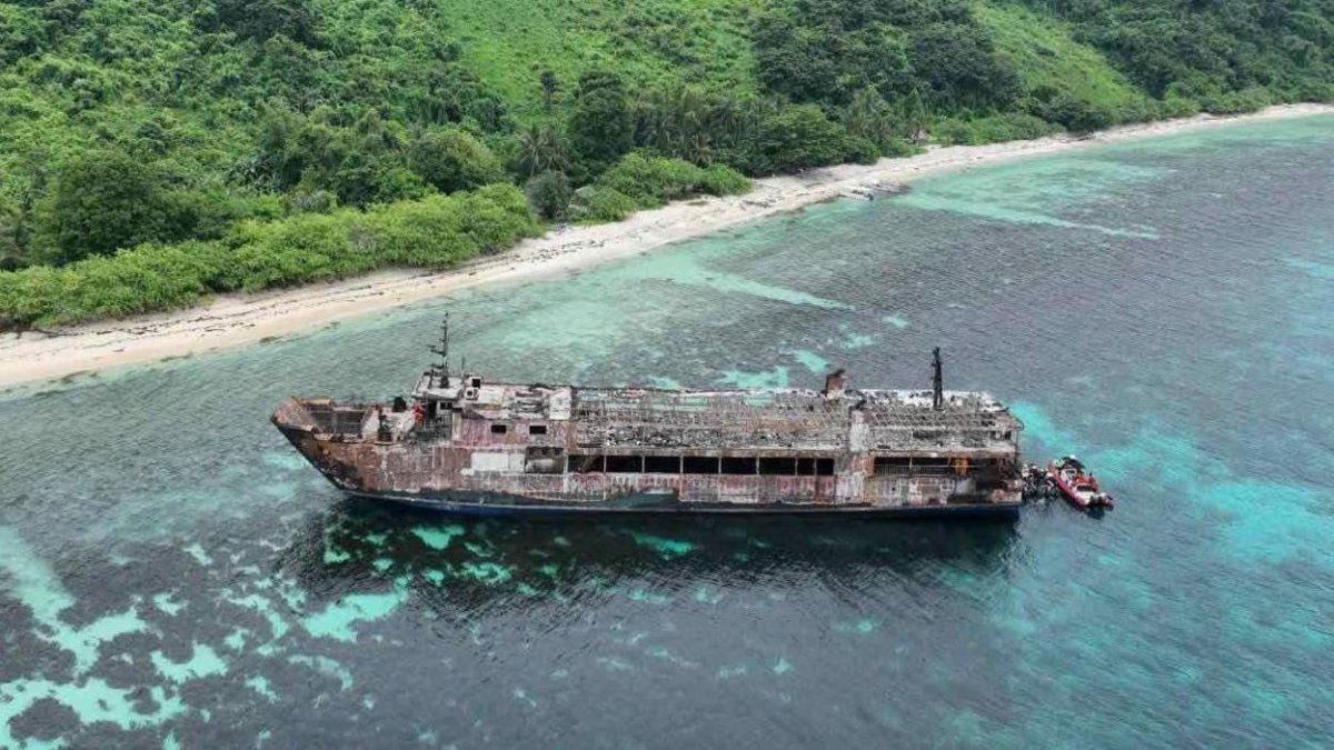 A handout photo made available by the Philippine Coast Guard shows an aerial view of a burnt ferry off Palawan province.